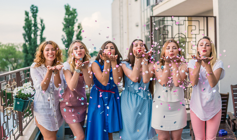 line of girls blowing confetti